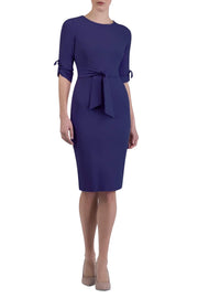 brunette model wearing diva catwalk tryst pencil navy blue dress with sleeves and belt detail at the front with rounded neckline front