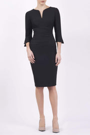 blonde model wearing seed tuscany pencil fitted dress in black colour with a split in the neckline and split detail on sleeves front
