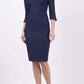 blonde model wearing seed tuscany pencil fitted dress in navy blue colour with a split in the neckline and split detail on sleeves front