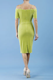 brunette model wearing diva catwalk wessex pencil velvet dress with off shoulder open neckline and overlapping front and short sleeves in tropical green colour back