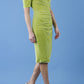 brunette model wearing diva catwalk wessex pencil velvet dress with off shoulder open neckline and overlapping front and short sleeves in tropical green colour front
