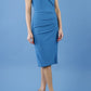 brunette model wearing diva catwalk evening pencil skirt dress sleeveless with lowered neckline and pleating on side in tropic teal colour front