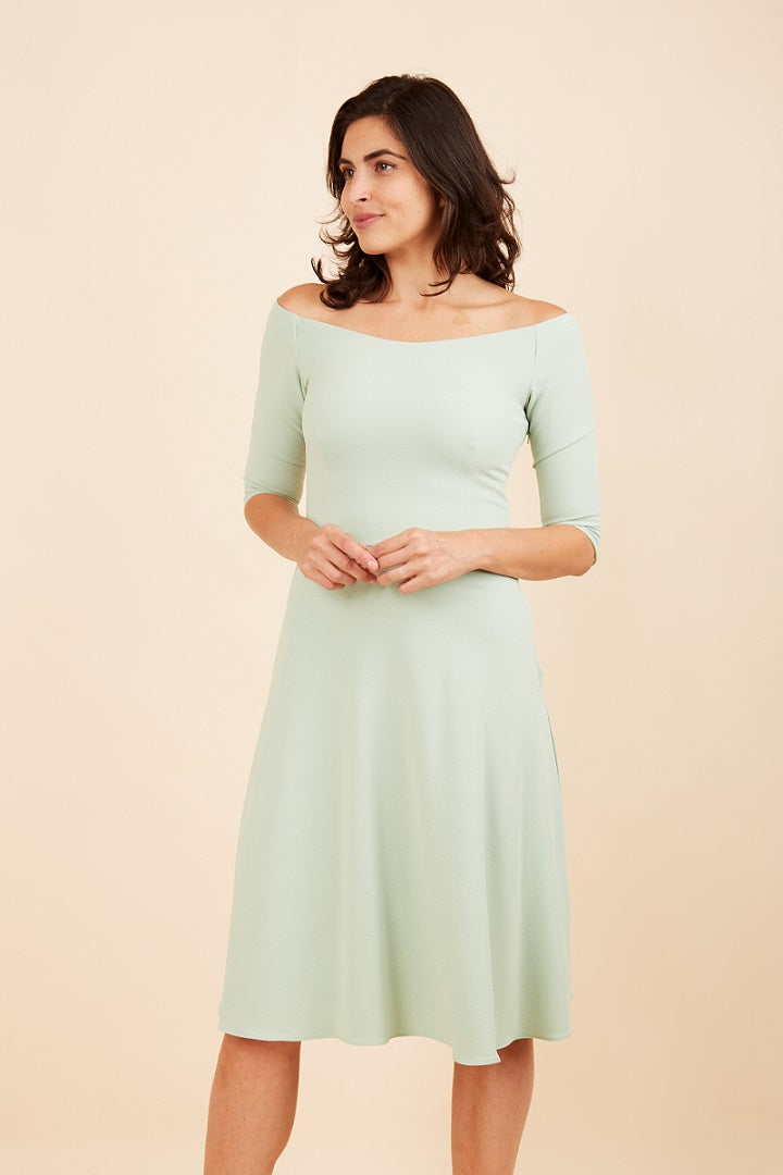 brunette model is wearing diva catwalk off shulder swing a-line islay dress with sleeves in deco green front