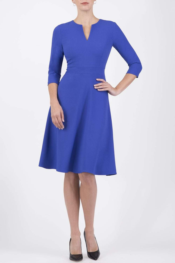 blonde model wearing diva catwalk romney three quarter sleeve swing dress with a band in riviera blue front