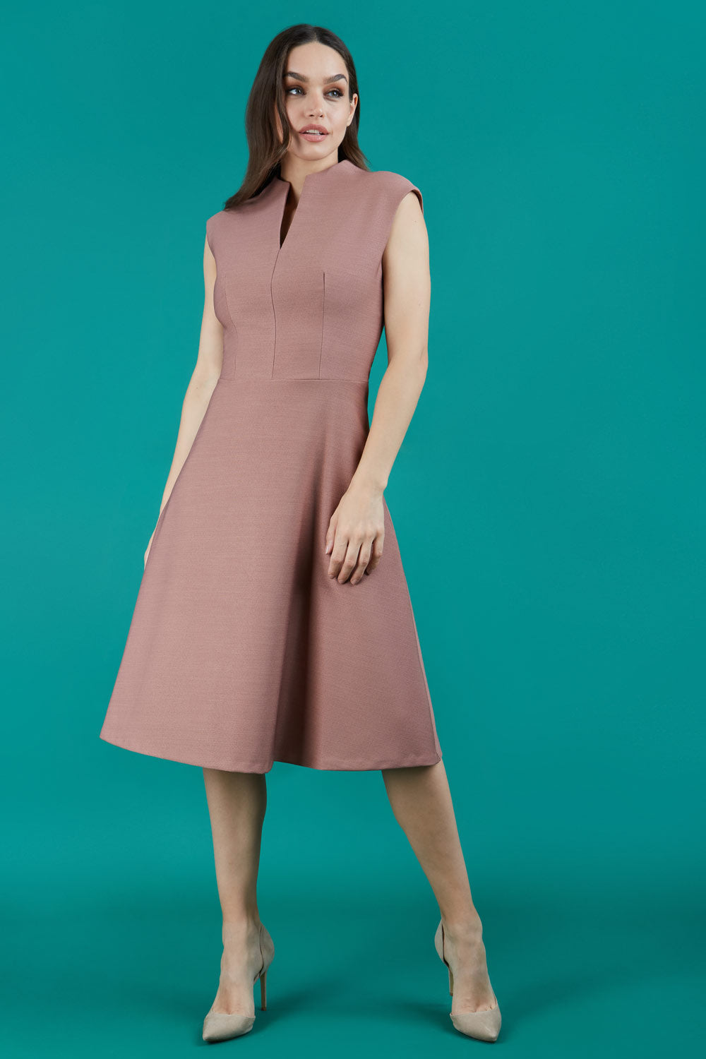 Brunette Model is wearing a sleeveless swing high neck dress with high neck in acorn brown by Diva Catwalk front