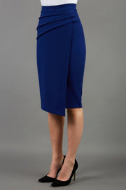 model is wearing diva catwalk antibe pencil asymmetric skirt with pleating at the front in oxford blue front