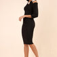 brunette model wearing diva catwalk carolina three quarter sleeve pencil dress with pleating across the tummy and assymetric triangle cuts out on neckline area and cold shoulder in black and white front