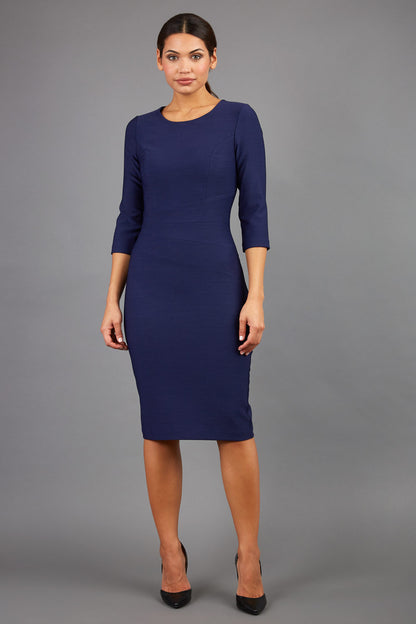 brunette model is wearing diva catwalk seed rosa plain dress with rounded neckline in navy blue front