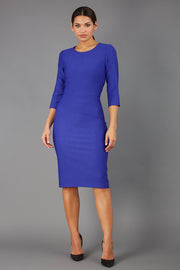 brunette model is wearing diva catwalk seed rosa plain dress with rounded neckline in palace blue front