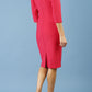 brunette model is wearing diva catwalk seed rosa plain dress with rounded neckline in opera pink back