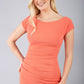 Model wearing Diva Catwalk Polly Rounded Neckline Pencil Cap Sleeve Dress with pleating across the tummy area in sea coral front