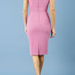 model is wearing diva catwalk polly cap sleeve pencil dress with rounded neckline at the front and deep lowered rounded cutout at the back in begonia pink back