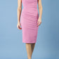 model is wearing diva catwalk polly cap sleeve pencil dress with rounded neckline at the front and deep lowered rounded cutout at the back in begonia pink front