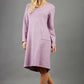 blonde model wearing diva catwalk irena cosy sleeved knee length dress with pockets and v-neckline in soft fabric pink front