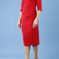 model is wearing diva catwalk pinhoe pencil dress with sleeved and high neckline with a keyhole detail in the middle and pleating across the tummy area in true red side