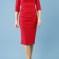model is wearing diva catwalk pinhoe pencil dress with sleeved and high neckline with a keyhole detail in the middle and pleating across the tummy area in true red front