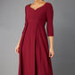 Brunette Model is wearing 3/4 sleeve sweetheart neckline  swing burgundy dress