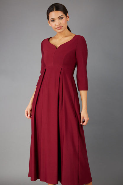 Brunette Model is wearing 3/4 sleeve sweetheart neckline  swing burgundy dress