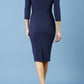 model is wearing diva catwalk polly sleeved pencil dress with low rounded neckline at the back in navy blue back