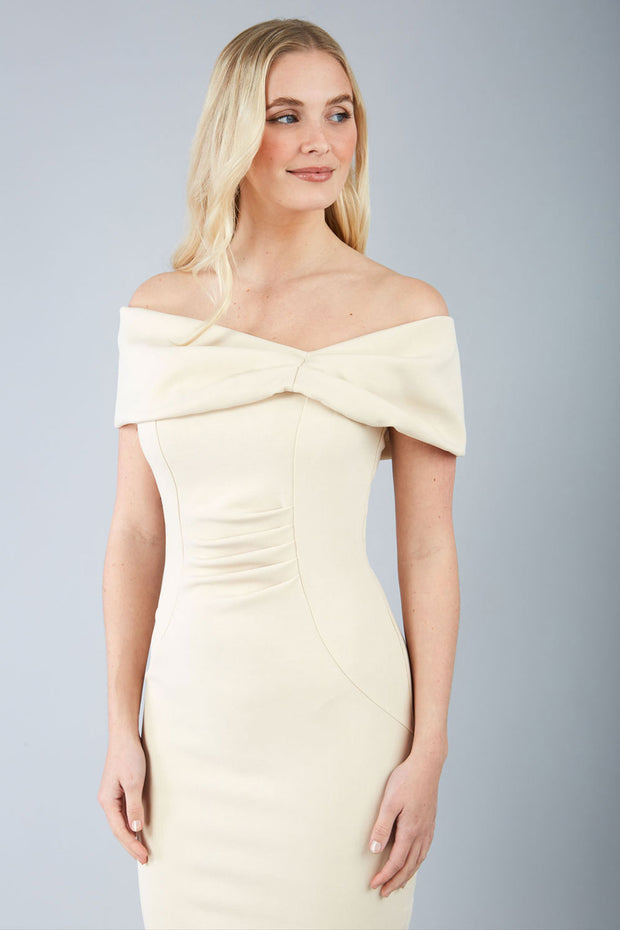 blonde model is wearing diva catwalk mariposa pencil dress with Detailed Bardot neckline with fold-over detail and pleated at waist area in beige front