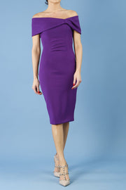blonde model is wearing diva catwalk mariposa pencil dress with Detailed Bardot neckline with fold-over detail and pleated at waist area in deep purple front