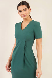 brunette model wearing diva catwalk tregony a-line dress with lowered v-neckline in hunter green and short sleeves front