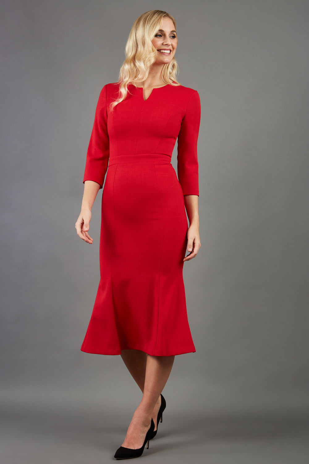 blonde model is wearing diva catwalk senne midaxi sleeved dress with fishtail and rounded neckline with a slit in the middle in red front