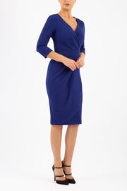 model wearing diva pencil dress tulip design with overlapping pencil skirt with 3 4 sleeves in colour oxford blue front 