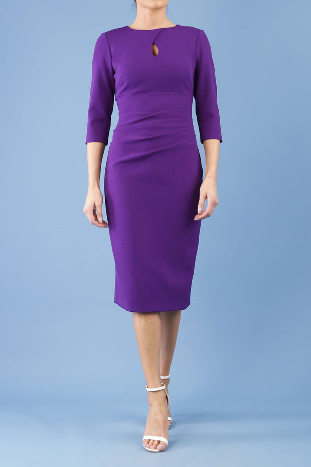 brunette model wearing diva catwalk ubrique pencil dress with a keyhole detail and sleeves in purple colour front