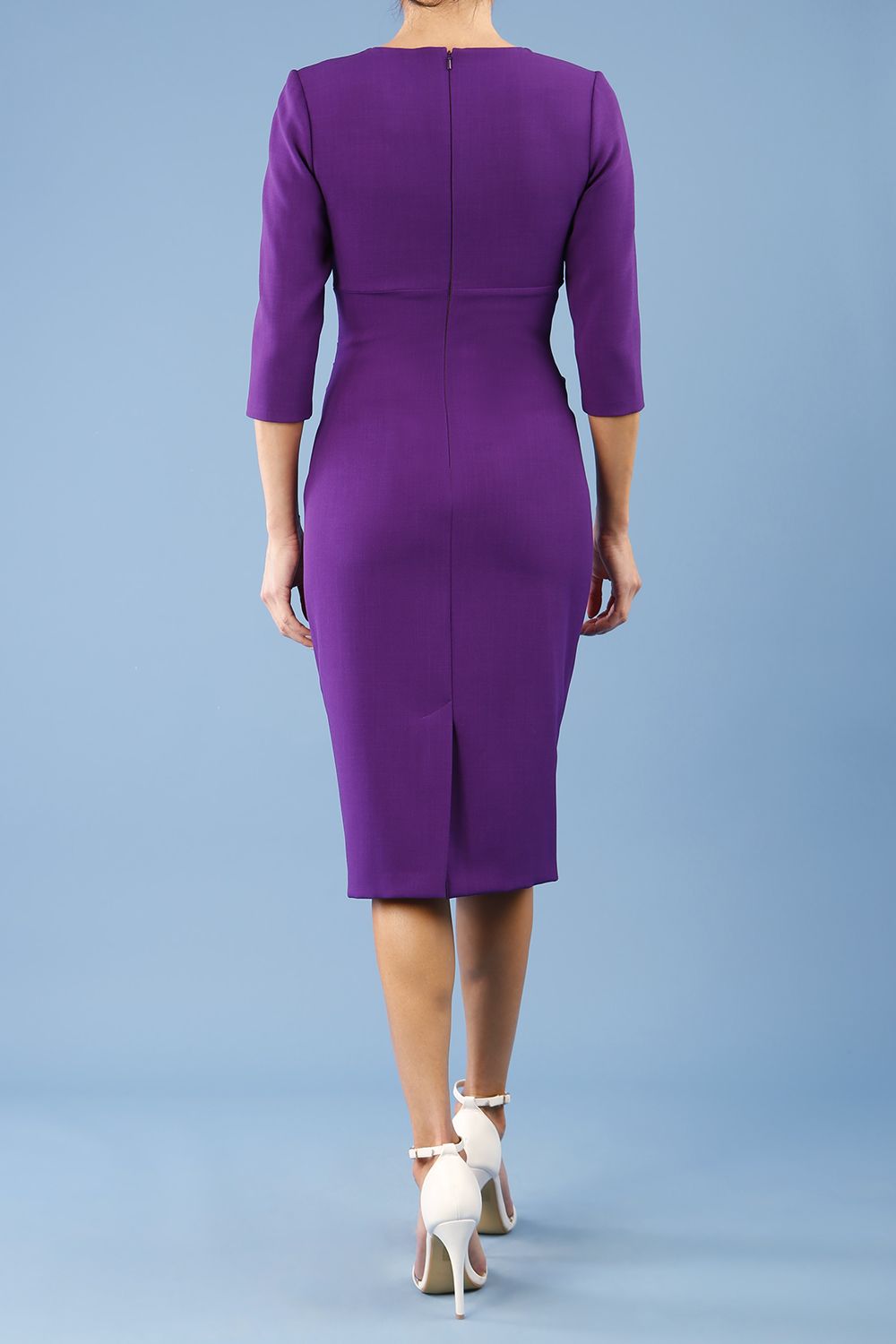 brunette model wearing diva catwalk ubrique pencil dress with a keyhole detail and sleeves in purple colour back