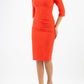 A model is wearing a three quarter sleeve pencil dress with a round neckline and bow detail at the front in orange