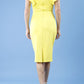 model wearing diva catwalk Bodiam Bodycon Pencil Dress with frill sleeves in knee length and pleating across the tummy in blazing yellow back