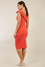 brunette model wearing diva catwalk rosita pencil skirt fitted dress with asymmetric neckline and bow detail at the top and it is a sleeveless design  with empire waistline in orange back