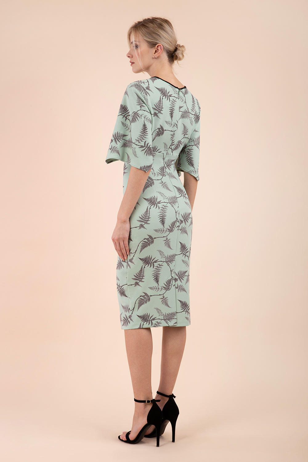 Model wearing the Diva Memphis Print dress dress in pencil dress design in deco green fern print front image
