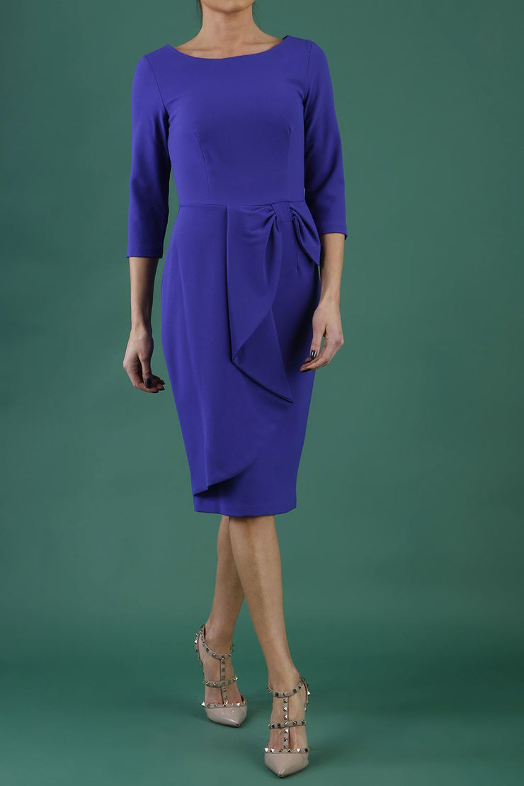 model is wearing diva catwalk jacky dress with rounded neckline 3/4 sleeve and bow detail on the waist in spectrum indigo front