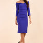 brunette model wearing diva catwalk evening pencil dress off shoulder with sleeves and pleated pencil skirt in colour indigo blue front