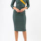 A brunette model is wearing a bi stretch pencil print mustard green dress by diva catwalk