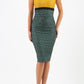 A model wearing a sleeveless pencil dress with a color block design, featuring a mustard yellow top and a green and black patterned skirt with pleating across the front.