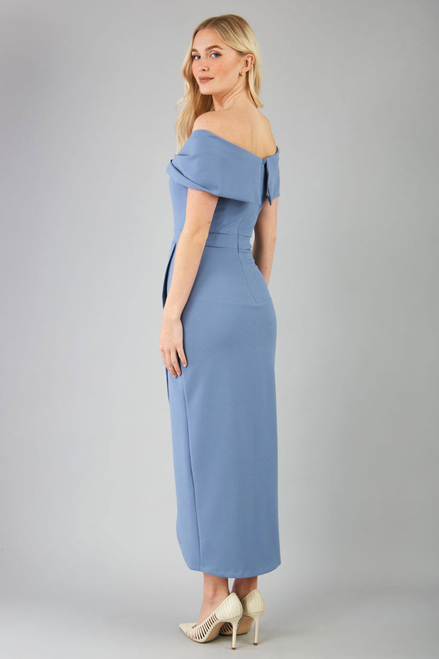 odel wearing diva catwalk vegas calf length stone blue midaxi dress with wide bardot neckline and open shoulders with a large opening at the front of the skirt with pleating coming down long skirt back
