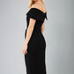 model wearing diva catwalk vegas calf length black midaxi dress with wide bardot neckline and open shoulders with a large opening at the front of the skirt with pleating coming down long skirt back