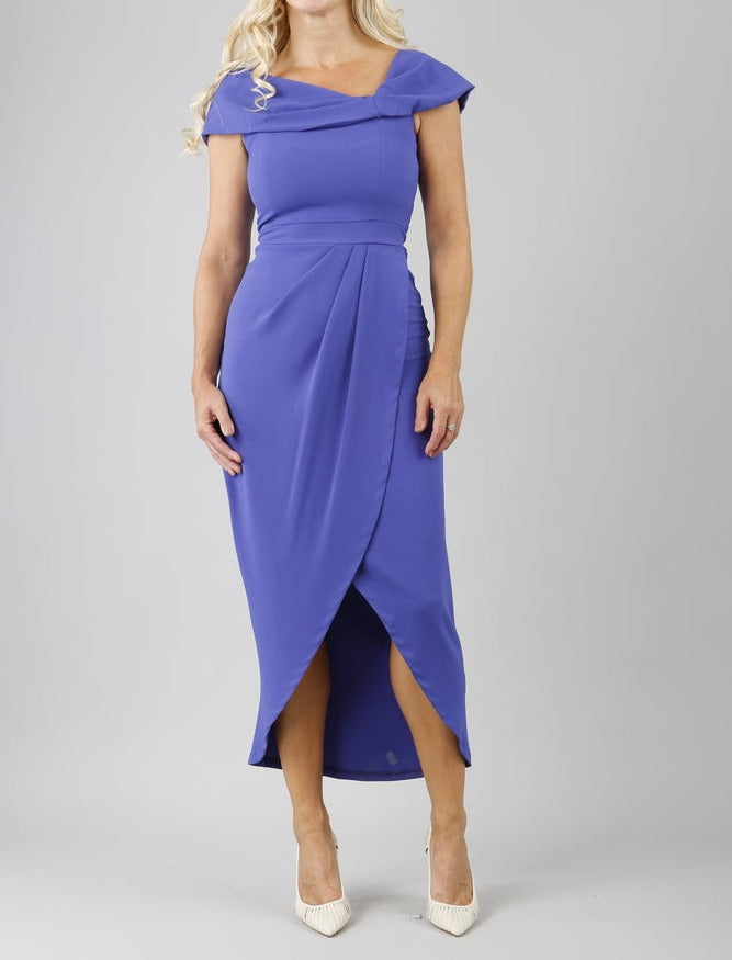 model wearing diva catwalk vegas calf length indigo midaxi dress with wide bardot neckline and open shoulders with a large opening at the front of the skirt with pleating coming down long skirt front