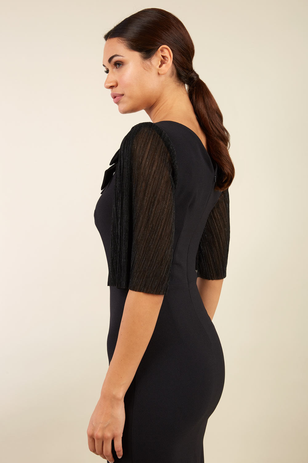 brunette model is wearing diva catwalk black pencil black dress with  bow back image