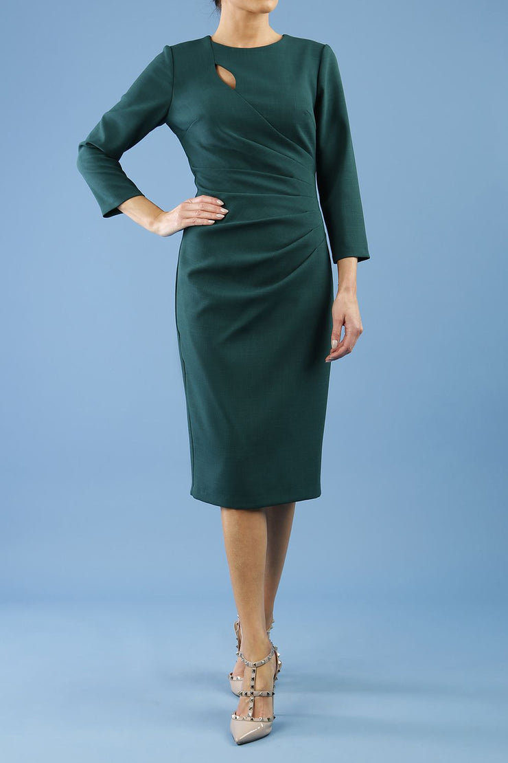 model is wearing diva catwalk miracle pencil dress with keyhole detail on a side of the front panel and gathering detail on a side or bodice panel with sleeves in forest green colour front
