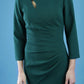 model is wearing diva catwalk miracle pencil dress with keyhole detail on a side of the front panel and gathering detail on a side or bodice panel with sleeves in forest green colour front