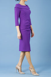 brunette model is wearing diva catwalk pencil dress with collar and a button detail on a side with 3/4 sleeve in passion purple front