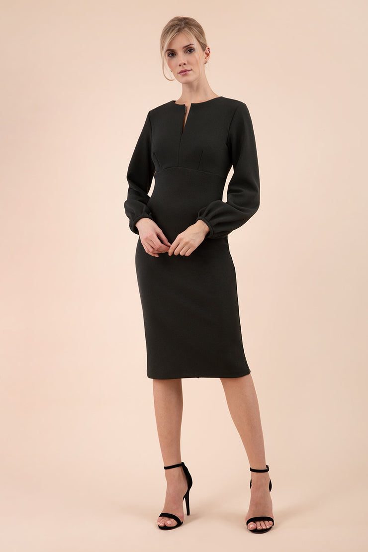 Blonde model wearing Diva Catwalk Praktica long puffed bishop sleeves knee length empire line pencil dress with round neckline with a slit cut in the middle in Deep Green front