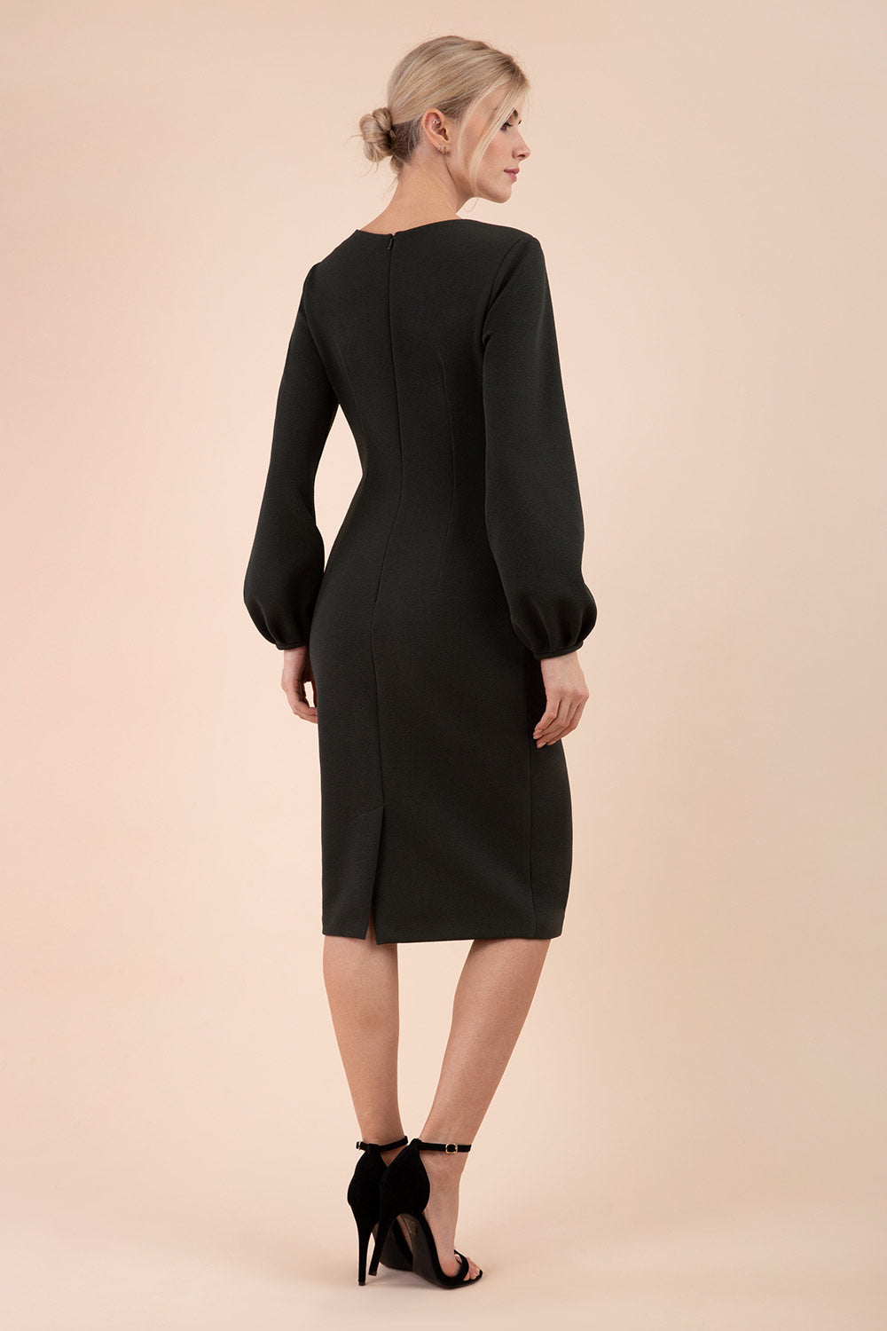 Blonde model wearing Diva Catwalk Praktica long puffed bishop sleeves knee length empire line pencil dress with round neckline with a slit cut in the middle in Deep Green back