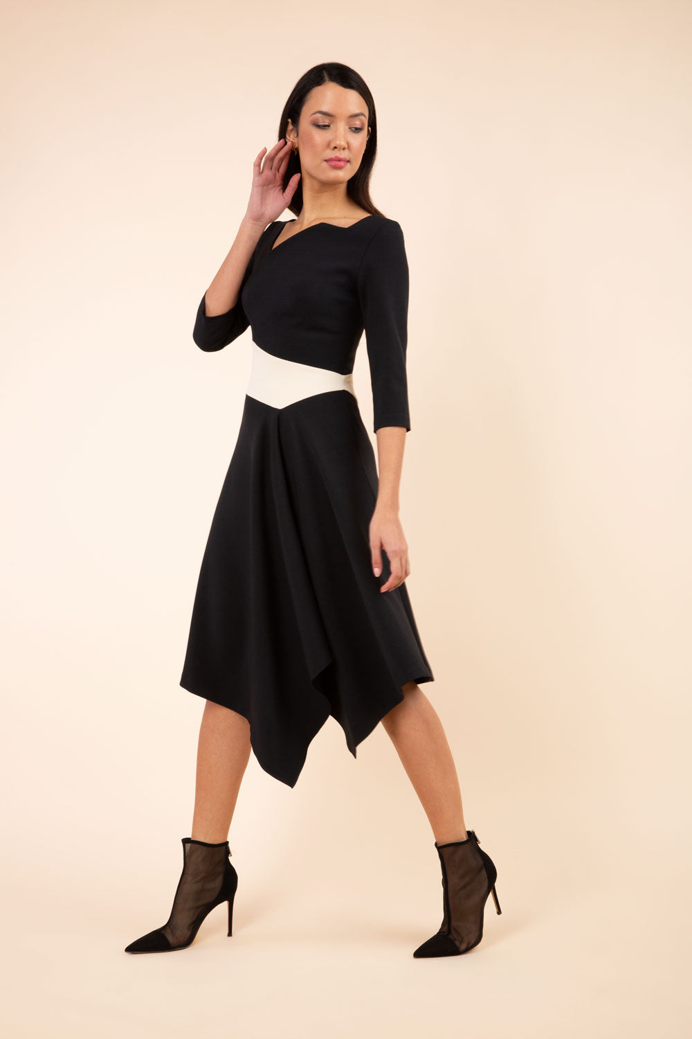 Model wearing Diva Catwalk Pinto Contrast swing a-line skirt Dress with asymmetric skirt and asymmetric neckline with three quarter sleeve in black and beige
