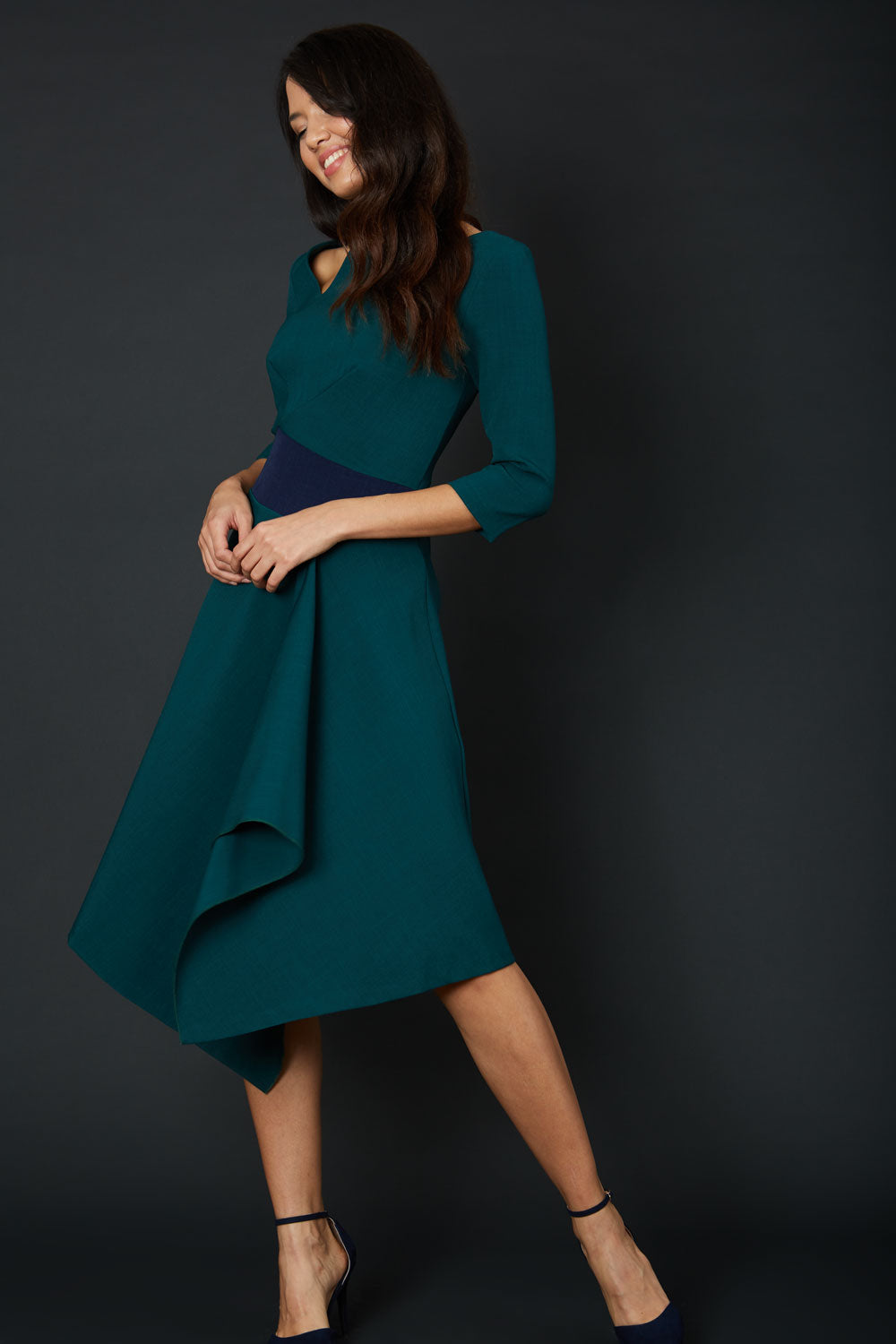 Brunette Model wearing Diva Catwalk Pinto Contrast Swing Dress with asymmetric skirt and asymmetric neckline with three quarter sleeve in Forest Green front