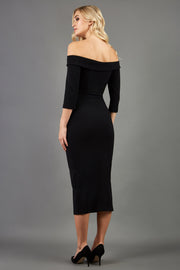 blonde model is wearing three quarter fitted dress off-shoulder with bardot neckline and buttons to front with pockets and vent on a skirt in black back image